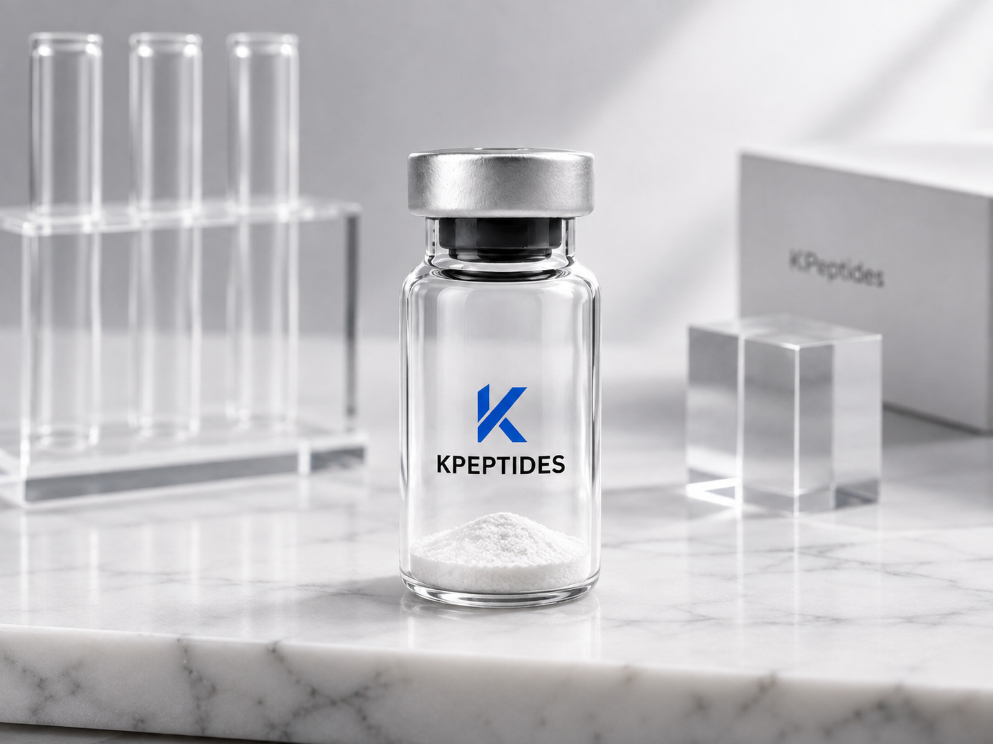 KPeptides branded research vial with lyophilised powder beside laboratory test tubes on white marble